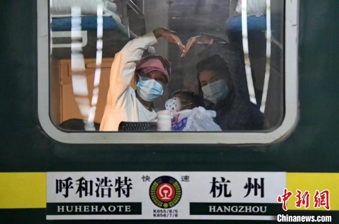 圖為登上轉(zhuǎn)運(yùn)火車的游客向額濟(jì)納比心?！⊥趵?攝