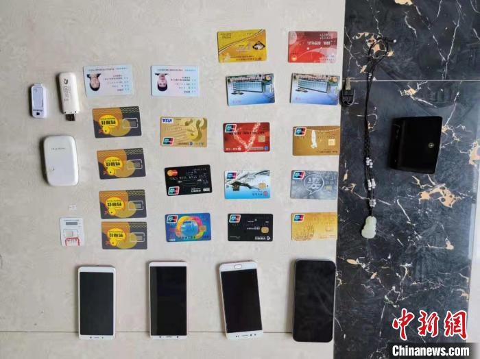 資料圖為果洛藏族自治州公安民警查扣的作案手機和涉案銀行卡?！‖斍呖h公安局供圖