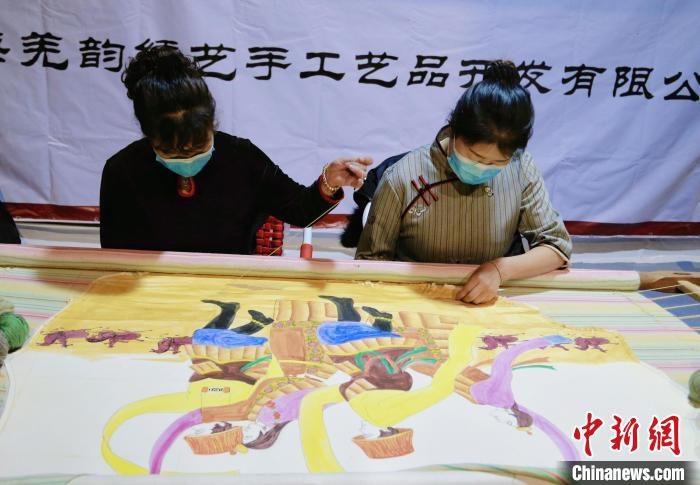 圖為皮繡藝人在市集上“秀”指尖技藝?！●R銘言 攝