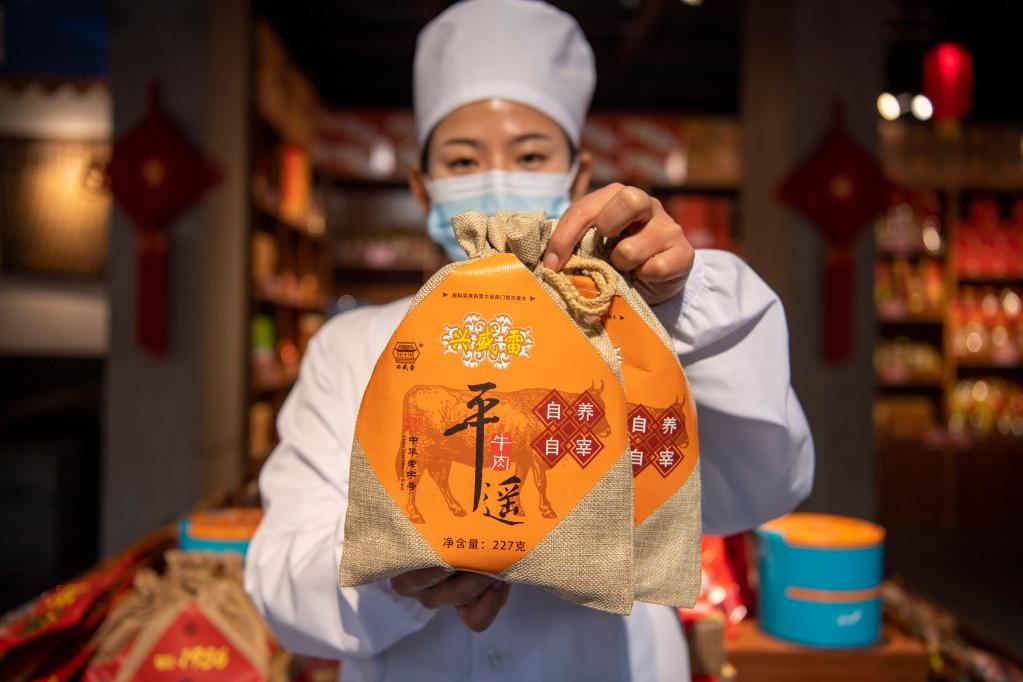 1月27日，在平遙古城南大街的一家平遙牛肉店內(nèi)，工作人員展示一款牛肉產(chǎn)品。新華社記者 楊晨光 攝