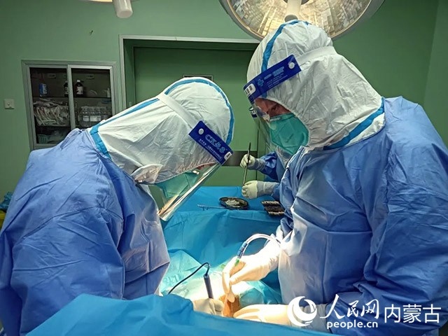 醫(yī)護(hù)人員正在為新冠肺炎合并腸梗阻腸穿孔的尿毒癥患者實施急診手術(shù)。呼和浩特市第一醫(yī)院供圖