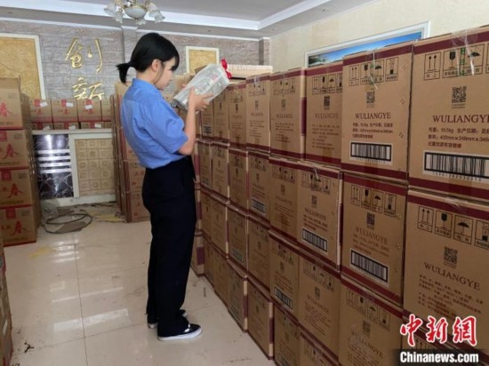 資料圖為檢察人員核對查獲的假冒品牌白酒。青海省人民檢察院供圖