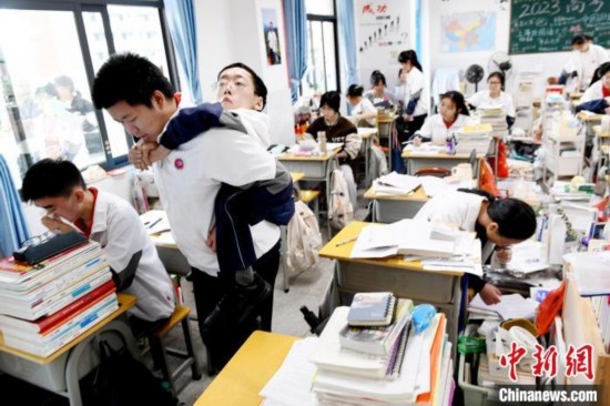 遇到鐘華強課堂上內急，江西省南康中學北校區(qū)的高三學生朱金祥便會及時背著他前往衛(wèi)生間。 卓忠偉 攝