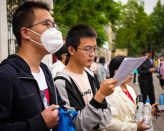 6月7日，在昆明市第五中學(xué)考場(chǎng)外，考生正利用最后時(shí)間復(fù)習(xí)備考。人民網(wǎng) 曾智慧攝