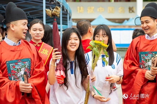 6月7日上午，在南寧市天桃實(shí)驗(yàn)學(xué)校翠竹校區(qū)，老師們?cè)跒榭忌鷤兗佑凸膭?！人民網(wǎng)記者 嚴(yán)立政攝