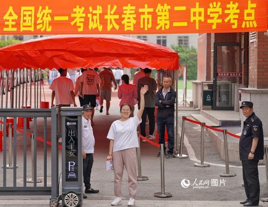 6月7日，在長(zhǎng)春市第二中學(xué)考點(diǎn)，一名考生信心滿滿進(jìn)入考場(chǎng)，并與家長(zhǎng)揮手致意。人民網(wǎng)記者 李洋攝
