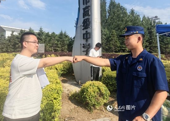 6月7日，遼寧營(yíng)口老邊區(qū)消防救援大隊(duì)的消防員為高考學(xué)子加油助威。人民網(wǎng)記者 尹柏寒?dāng)z