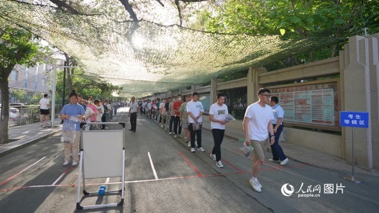 6月7日，烏魯木齊市第七十中學(xué)門口，考生們有序進(jìn)入考場(chǎng)。人民網(wǎng) 李欣洋攝