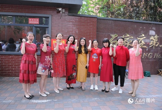 6月7日，在石家莊第二十七中學(xué)考點(diǎn)，家長(zhǎng)身著旗袍，為高考的孩子們加油助威！紅紅火火、旗開(kāi)得勝！人民網(wǎng)記者 周博攝