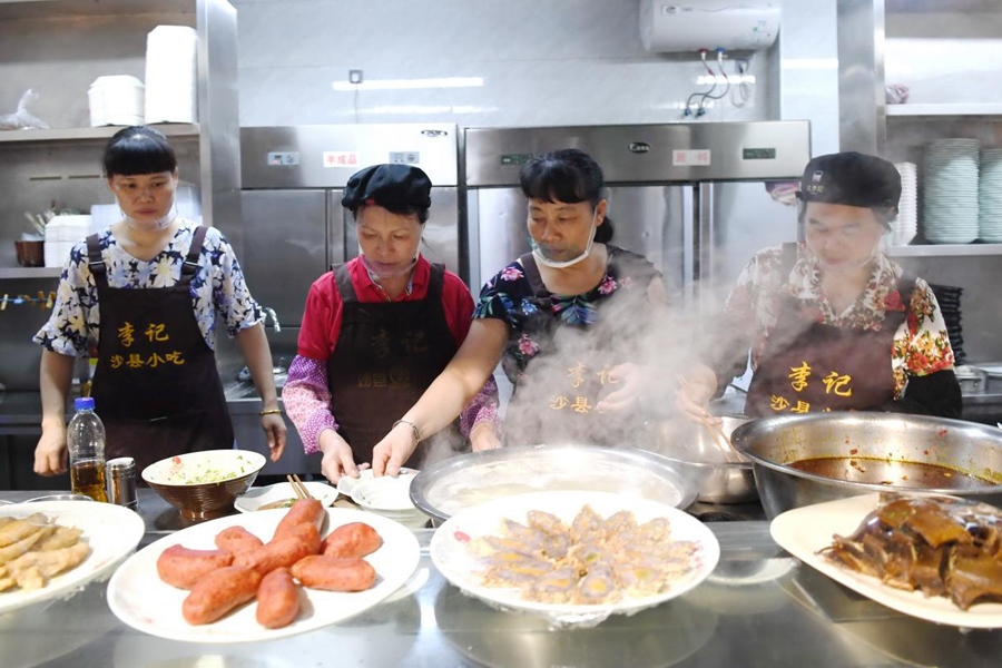 福建三明市沙縣區(qū)一家小吃店工作人員在為客人準(zhǔn)備特色小吃。 新華社記者 林善傳 攝