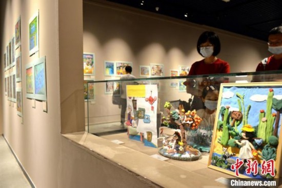 圖為家長(zhǎng)帶著孩子參觀展覽。呂明 攝