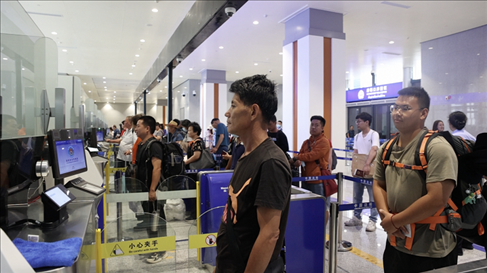 6月13日，乘坐中老鐵路國(guó)際旅客列車的旅客在磨憨邊檢大廳排隊(duì)候檢。李揚(yáng) 攝