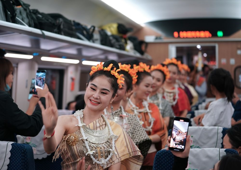 2023年4月13日，老撾工作人員在D887次國(guó)際旅客列車上表演。當(dāng)日，中老鐵路從中國(guó)昆明南站、老撾萬象站雙向?qū)﹂_D887次和D888次國(guó)際旅客列車，兩地乘火車可當(dāng)日通達(dá)。中老鐵路是高質(zhì)量共建“一帶一路”的標(biāo)志性工程。新華社記者 邢廣利 攝