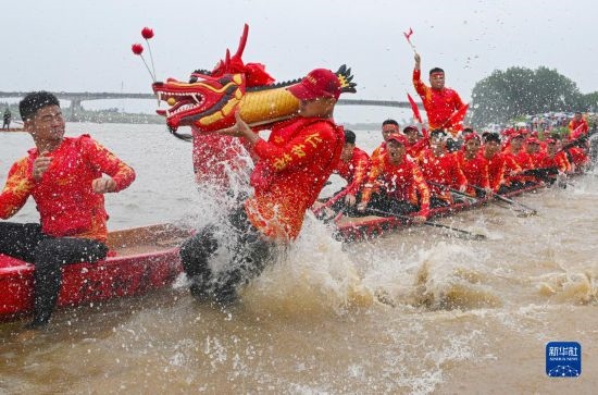 6月22日，在湖南省岳陽市湘陰縣湘江臨資口水域，參加龍舟賽的隊員接“龍頭”下水。