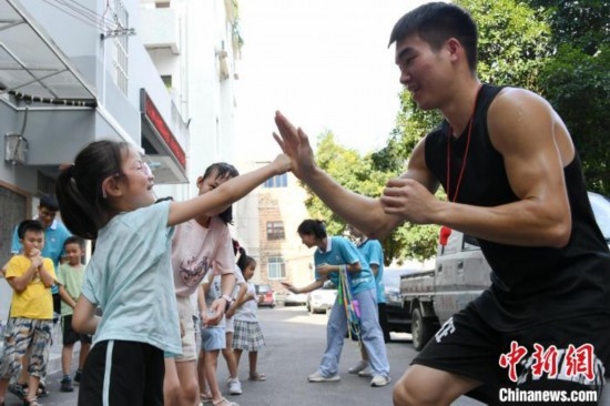 圖為大學(xué)生志愿者在組織孩子們參加體育健身活動。廖光福 攝