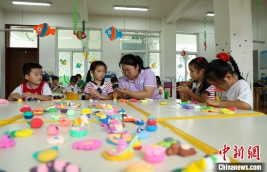 在肥西縣山南鎮(zhèn)中心幼兒園，孩子們?cè)诶蠋煹闹笇?dǎo)下做彩色泥塑。陳家樂 攝