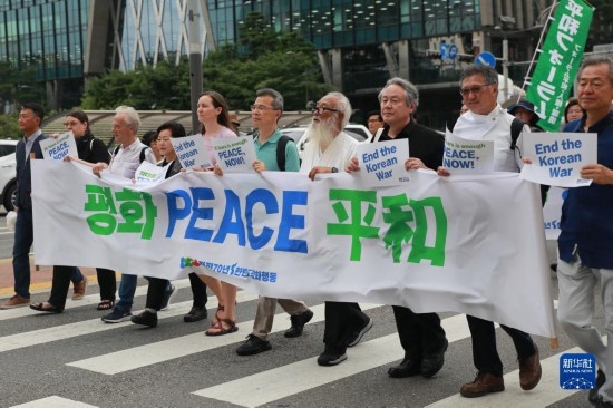 7月22日，在韓國首爾，人們手舉標(biāo)語參與反戰(zhàn)游行。新華社發(fā)（楊暢 攝）