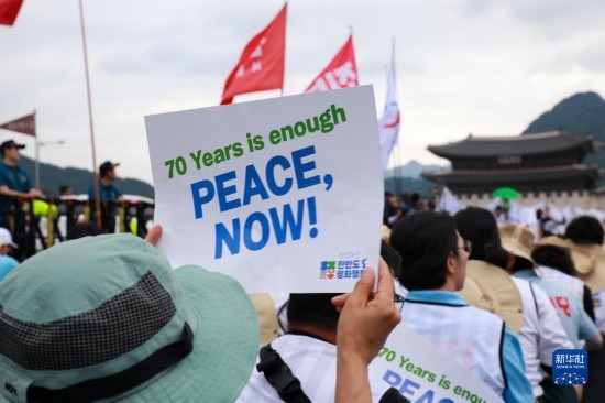 7月22日，在韓國首爾，人們手舉標(biāo)語參與反戰(zhàn)游行。新華社發(fā)（楊暢 攝）