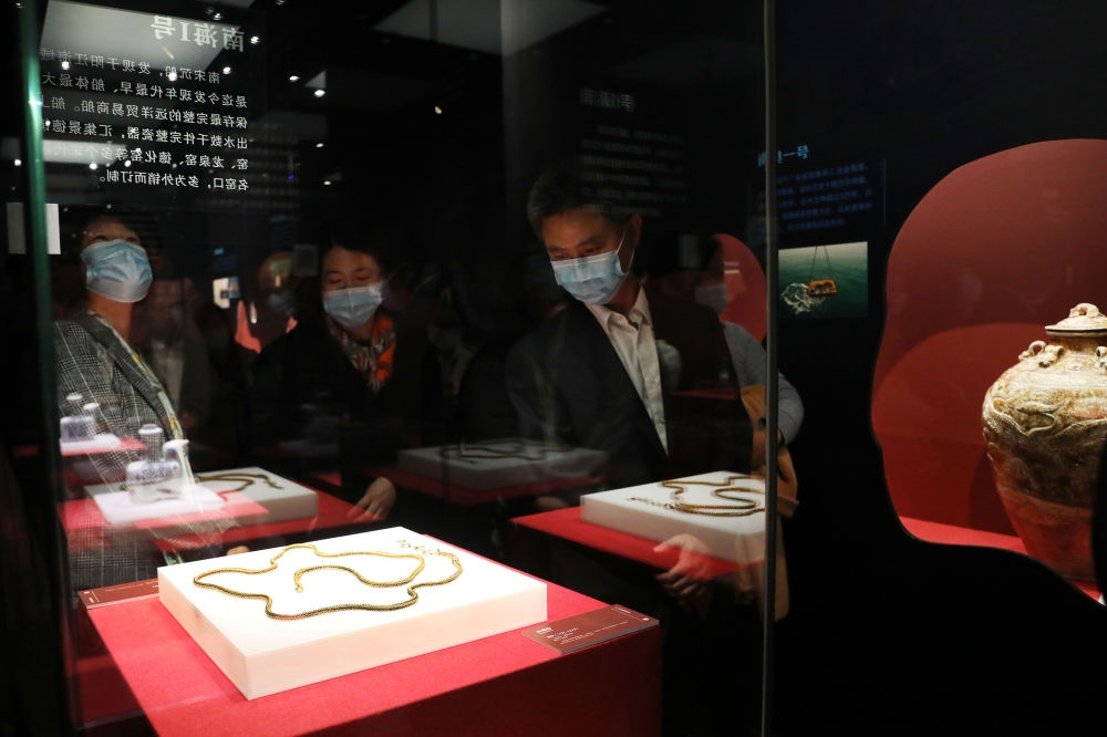 參觀者在上海臨港新城的中國航海博物館航海文物展上的“南海一號”出水的宋代金項飾展柜前駐足觀看（2020年12月28日攝）。新華社記者 方喆 攝