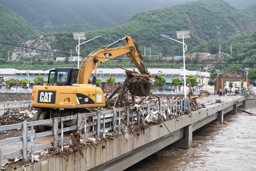 8月1日，在北京市門頭溝區(qū)水峪嘴村村口，一臺挖掘機在清理阻斷橋梁交通的雜物。目前該條道路已經(jīng)疏通完成。新華社記者 鞠煥宗 攝