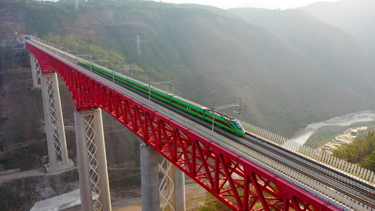 中老鐵路國際旅客列車在云南省境內的元江特大橋上飛馳。姚巍攝