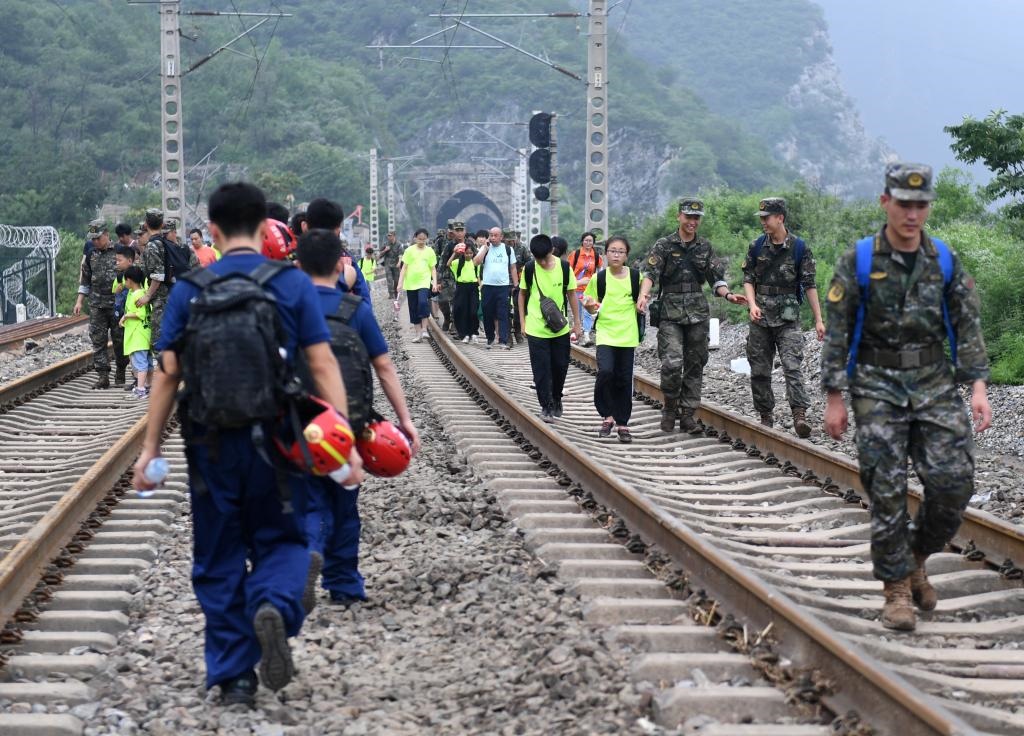 8月2日，部分滯留在北京市門頭溝山區(qū)受困列車的旅客，在救援人員幫助下前往轉(zhuǎn)運(yùn)客車。新華社記者張晨霖 攝