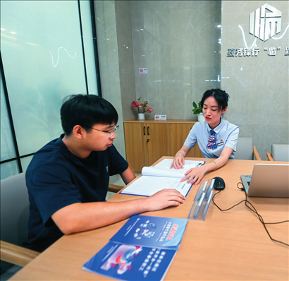 在杭州市臨安區(qū)政務(wù)服務(wù)中心的“為企服務(wù)中心”，黨員志愿者（右）解答企業(yè)主的疑問（2023年7月7日攝）。徐昱攝/本刊