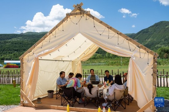 8月12日，游客在寧夏固原市涇源縣大灣鄉(xiāng)楊嶺村品嘗當地美食。新華社記者 李旭倫 攝