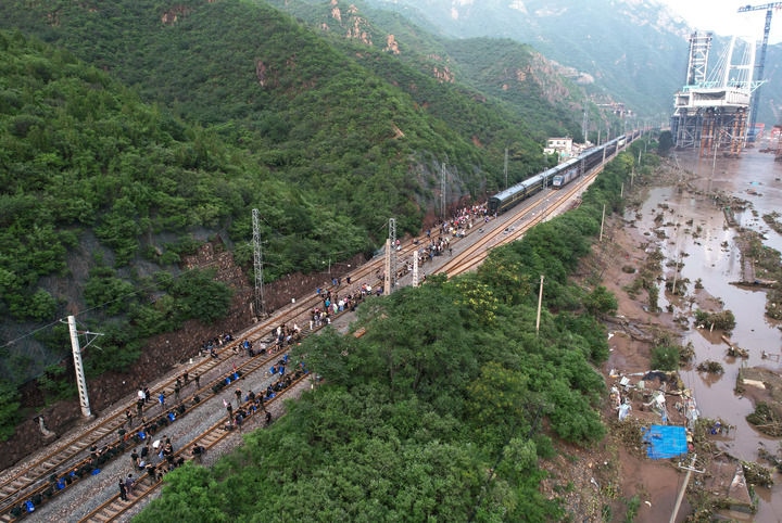 8月2日，受困列車旅客在救援人員幫助下徒步趕往轉(zhuǎn)運(yùn)客車（無人機(jī)照片）。新華社記者 張晨霖 攝