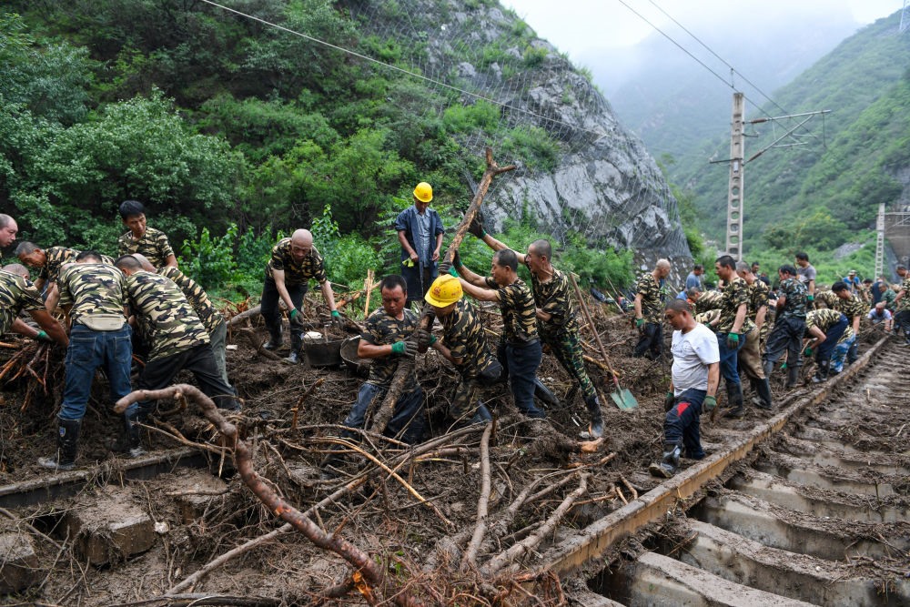 8月1日，在北京市門頭溝區(qū)水峪嘴村附近一段被阻斷的鐵路線上，中鐵六局工作人員在清理軌道上的雜物，全力恢復(fù)交通。新華社記者 鞠煥宗 攝