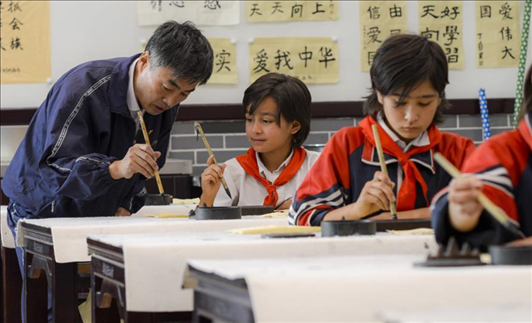 △新疆疏附縣托克扎克鎮(zhèn)中心小學書法教室內(nèi)，同學們正在學習寫毛筆字。