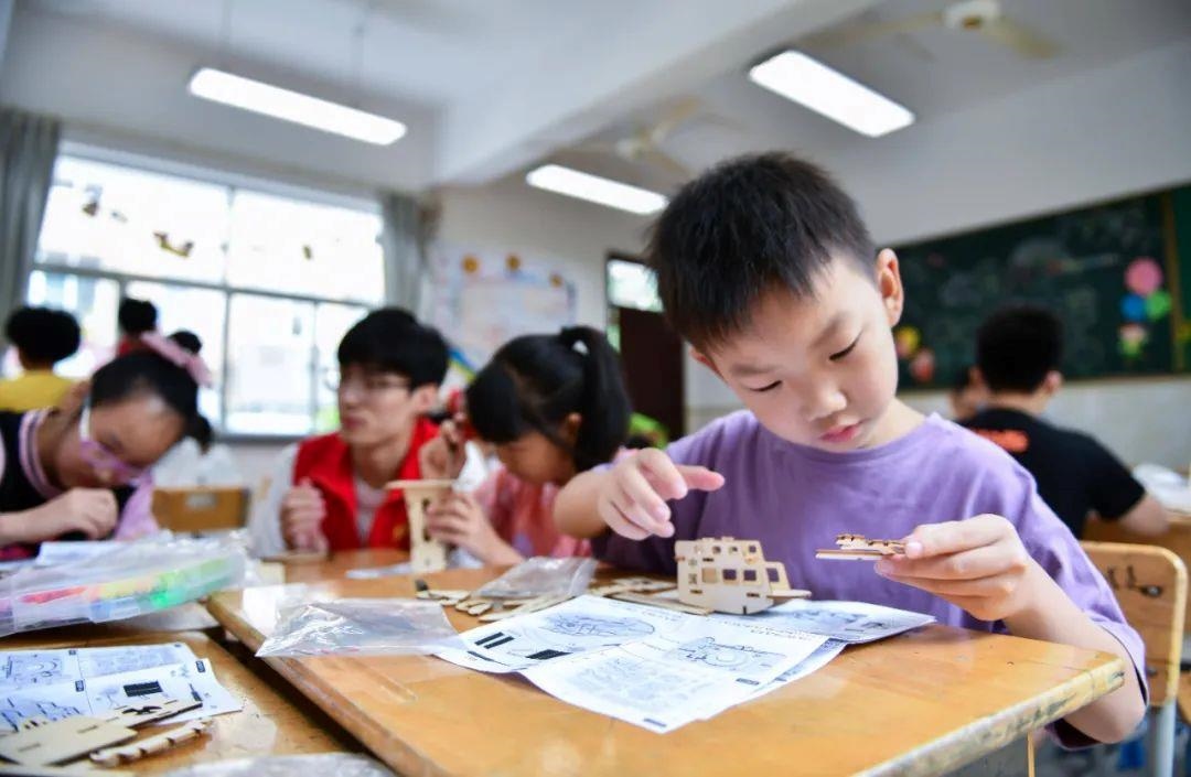 △今年7月，在浙江余姚市舜北小學暑托班內(nèi)，孩子們制作太陽能科學實驗裝置。