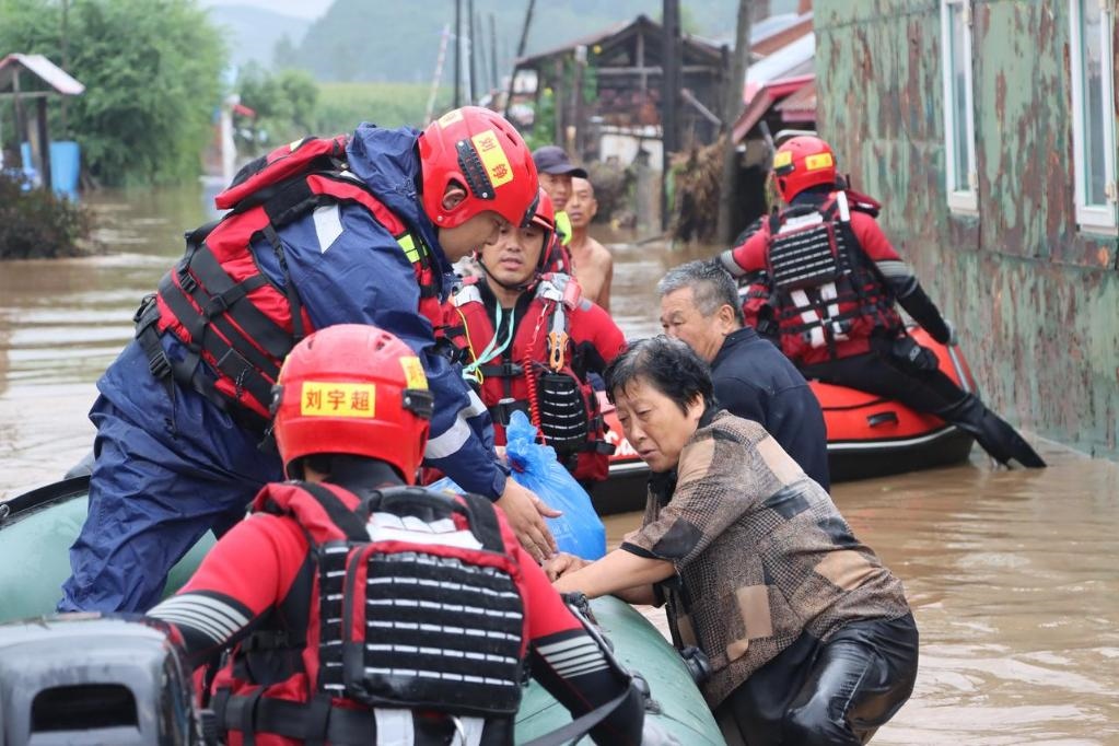 8月4日，在黑龍江省尚志市一面坡鎮(zhèn)萬(wàn)山村，哈爾濱市森林消防支隊(duì)的消防員在解救被困村民。新華社發(fā)