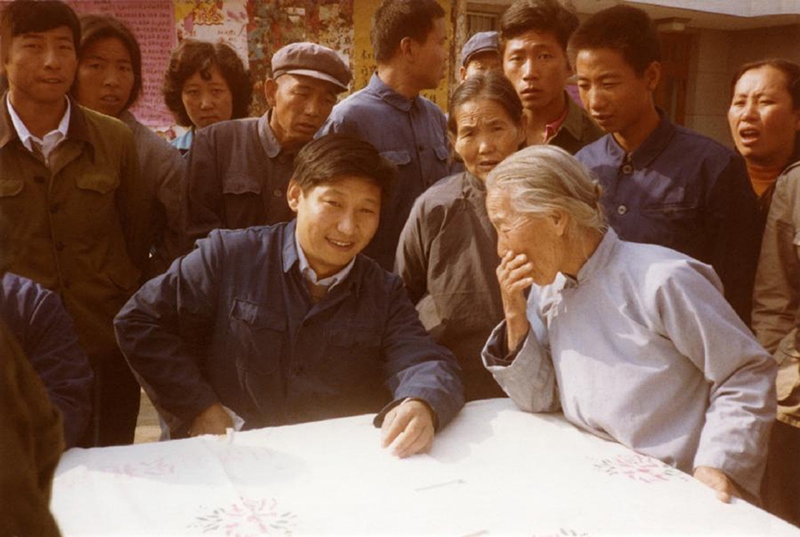 1983年，時(shí)任河北正定縣委書記的習(xí)近平（前排居中）臨時(shí)在大街上擺桌子聽取老百姓意見。