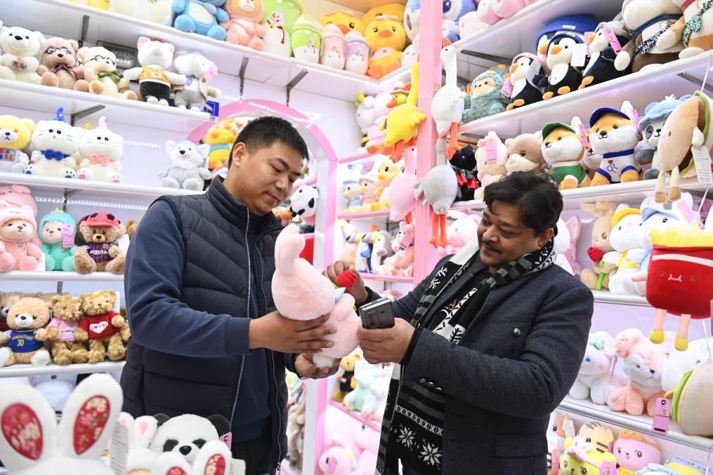2023年2月2日，來自印度的客商（右）在義烏國際商貿(mào)城的一家玩具店鋪內(nèi)選購商品。新華社記者 黃宗治 攝