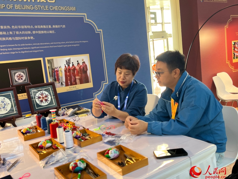 記者在新聞中心非遺傳承人展區(qū)進(jìn)行體驗(yàn)。人民網(wǎng)記者 杜燕飛攝