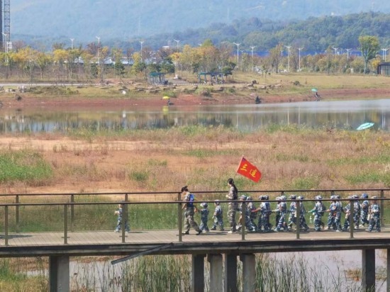 10月24日，秋游的幼兒園小朋友在老師帶領(lǐng)下走在清水塘公園里的木橋上。本報(bào)記者 常雯宜攝