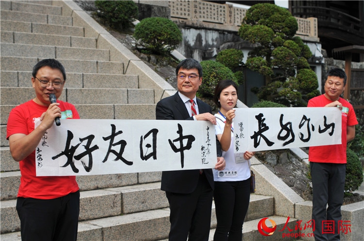 東京中國(guó)文化中心主任羅玉泉展示其為本次活動(dòng)書(shū)寫(xiě)的題詞“中日友好，山高水長(zhǎng)”。人民網(wǎng) 蔣曉辰攝