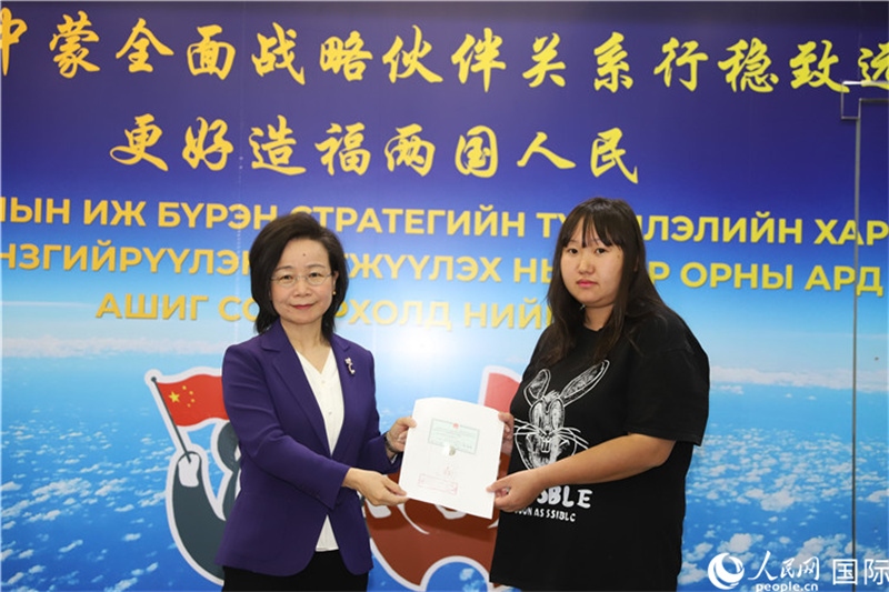 11月10日，沈敏娟大使向蒙古國(guó)公民尼亞姆庫(kù)（右）頒發(fā)最后一份領(lǐng)事認(rèn)證書。人民網(wǎng)記者 霍文攝