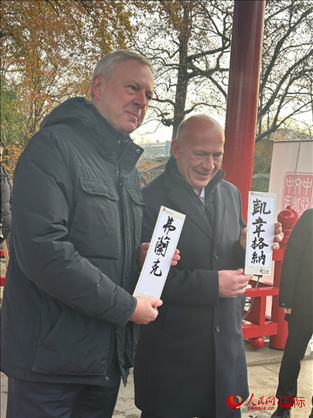柏林市長(zhǎng)韋格納（右）、動(dòng)物園監(jiān)事會(huì)主席布魯克曼（左）手持中國(guó)文化中心工作人員現(xiàn)場(chǎng)手書(shū)的中文名字。人民網(wǎng)記者 徐馨攝