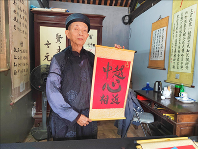 越南首都河內(nèi)文廟內(nèi)，阮明珠展示“中越心相近”書(shū)法作品。