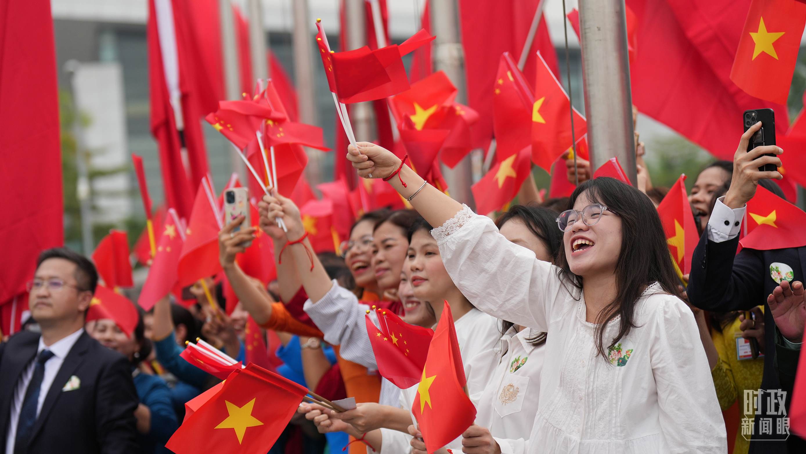 △人們揮舞兩國旗幟歡迎習(xí)近平訪越。（總臺國廣記者李晉拍攝）
