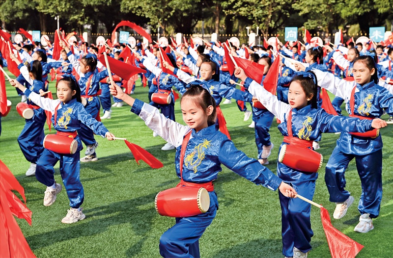 為助推民族地區(qū)基礎(chǔ)教育事業(yè)發(fā)展，廣西重新核定各地中小學(xué)教職工編制，依托全區(qū)編制“周轉(zhuǎn)池”核增事業(yè)編制給各地中小學(xué)，在全面達(dá)到國家標(biāo)準(zhǔn)的基礎(chǔ)上，進(jìn)一步統(tǒng)籌優(yōu)化和動(dòng)態(tài)調(diào)整各區(qū)域、學(xué)校、學(xué)段間編制資源。圖為2023年11月29日，南寧市濱湖路小學(xué)舉行主題為“逐夢(mèng)新時(shí)代 健體向未來”的體育文化節(jié)，孩子們正在跳腰鼓舞。 新華社記者 周華/攝
