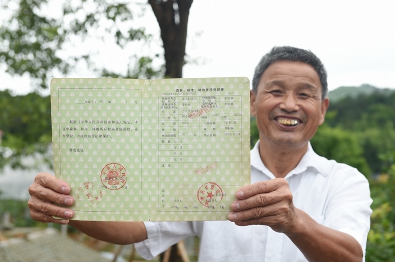 福建武平縣萬安鎮(zhèn)捷文村村民李桂林展示林權改革后領到的全國第一本新式林權證。