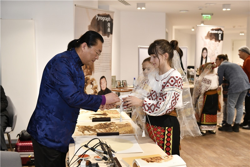 圖為羅馬尼亞小學(xué)生在現(xiàn)場體驗(yàn)烙畫。 布加勒斯特中國文化中心供圖
