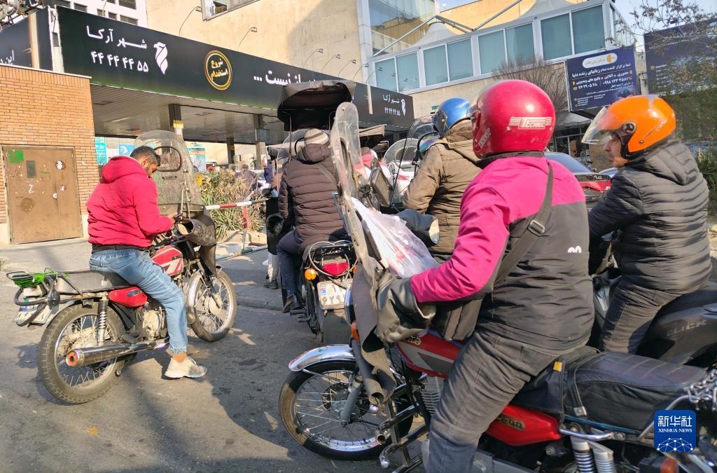 12月18日，摩托車在伊朗首都德黑蘭的一家加油站外等待加油。新華社記者 沙達提 攝