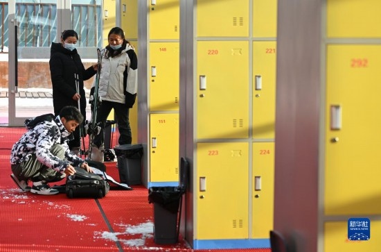 12月21日，游客在滑雪服務(wù)大廳整理滑雪裝備。