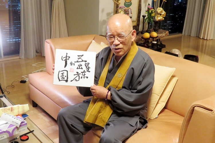 小島康譽(yù)展示自己書(shū)寫(xiě)的“五星出東方利中國(guó)”。視頻截圖