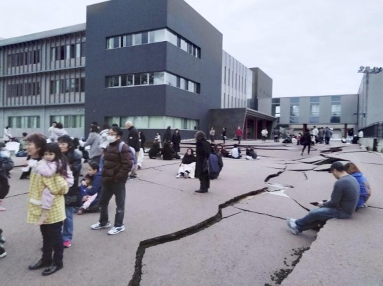  1月1日，在日本石川縣輪島市，人們站在被地震破壞的地面上。新華社/共同社