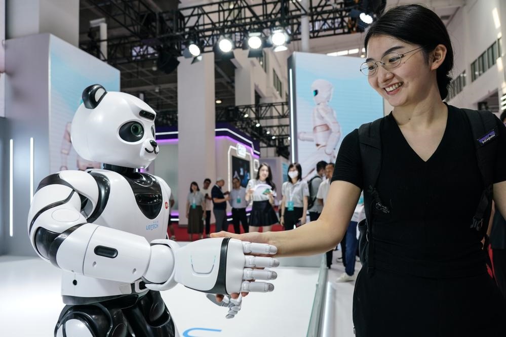 2023年8月16日，一名女士在北京舉辦的2023世界機(jī)器人大會(huì)現(xiàn)場(chǎng)與智能機(jī)器人握手。新華社記者彭子洋攝